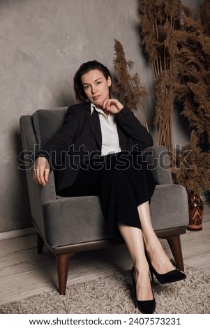A woman sits in an armchair in an office