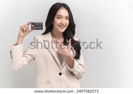 Studio portrait photo of young beautiful Asian woman feeling happy or surprise shock pointing at credit card on white background can use for advertising or product presenting concept.