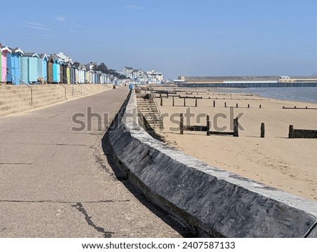 sea wall Essex UK. beach huts and pier. Royalty-Free Stock Photo #2407587133