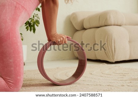young flexible girl doing gymnastics, flexibility and stretching using a yoga wheel online on a white background