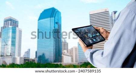 Smart Building management system(BMS) concept.Engineer Hands using digital tablet with Building Management Software on blurred modern office building as background