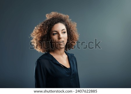 Curly-haired Latina woman's face illuminates with the joy of an insightful breakthrough Royalty-Free Stock Photo #2407622885