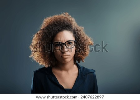 With an earnest frown and thick-rimmed glasses, her expression suggests deep thought or concern Royalty-Free Stock Photo #2407622897