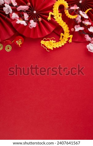 Sending happiness and prosperity this Chinese New Year 2024. Top view vertical photo of gold dragon, folding fans, traditional coins, sakura, lanterns on red background with advert zone