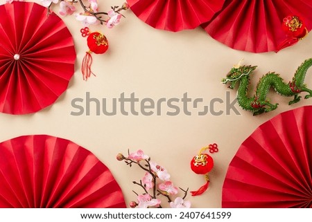 Embracing the customs of a Traditional Chinese New Year celebration. Top view shot of red folding fans, sakura, green dragon, lanterns on beige background with advert spot