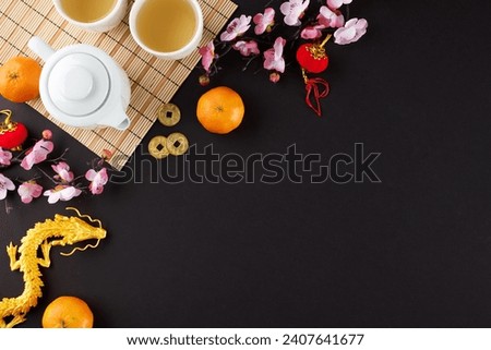Elevating celebrations through the chinese New Year tea ceremony. Top view shot of teapot, cups of tea, gold dragon, mandarins, traditional chinese elements on black background with promo zone