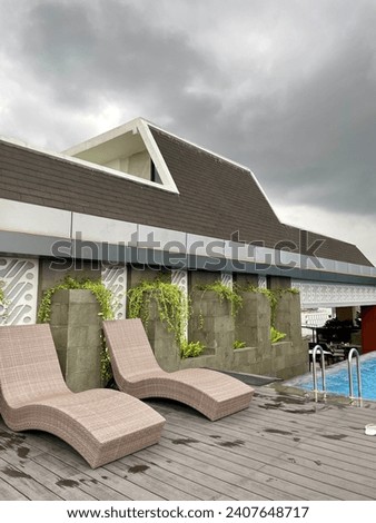 Potrait picture of hotel pool with two sunlounger