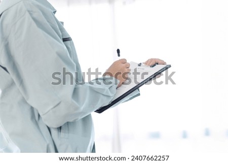Hands of an Asian worker doing inspection Royalty-Free Stock Photo #2407662257