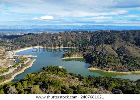 Aerial view of Stevens Creek Reservoir in Santa Clara County, California during winter. Background Silicon Valley.