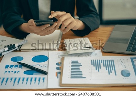 Accountant using calculator with laptop computer, budget and loan documents, Asian businesswoman meeting online to discuss project plans and financial results in office, close-up shot