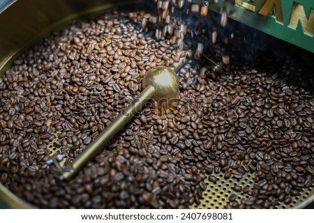 Picture of releasing freshly roasted coffee beans from the machine into the air dryer rack.
