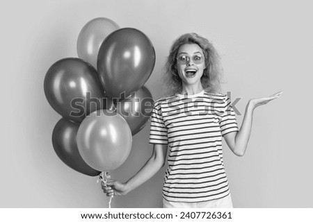 surprised girl with birthday balloon in sunglasses. happy birthday girl hold party balloons