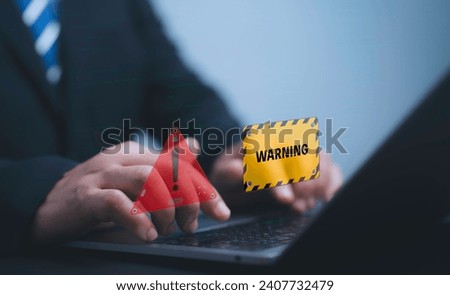 Cyber security and cybercrime concept.Cyber attack on computer network, Virus, Spyware, Malware or Malicious software. businessman using laptop with triangle caution warning sign.