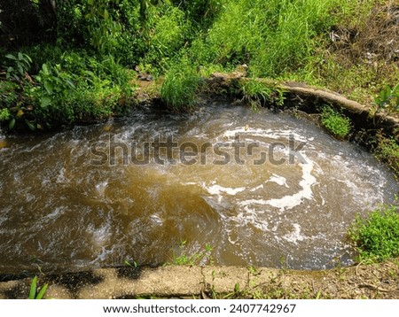 Swirls and streams of turbid water from irrigation discharge Royalty-Free Stock Photo #2407742967