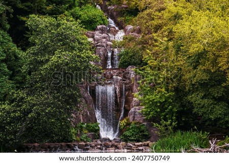 Huntington Falls, an artificial waterfall flowing from the top of Strawberry Hill and into Stow lake, Golden Gate Park, San Francisco, California Royalty-Free Stock Photo #2407750749