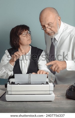 People in the office in the twentieth century. Manager and secretary from the past at work in the office Royalty-Free Stock Photo #2407756337