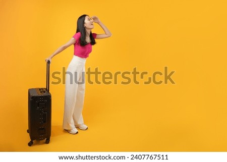 Full length of young asian woman wear summer casual clothes walk go with suitcase bag isolated on plain yellow background. Tourist travel abroad in free spare time rest getaway.  Royalty-Free Stock Photo #2407767511