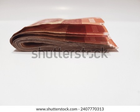 One hundred thousand rupiah banknote folded on white background, Indonesia Currency, 100.000 IDR.