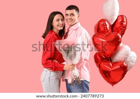 Young couple with roses and heart-shaped balloons on pink background. Valentine's Day celebration