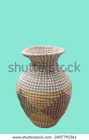 Decorative rattan braided flower vase isolated on green background
