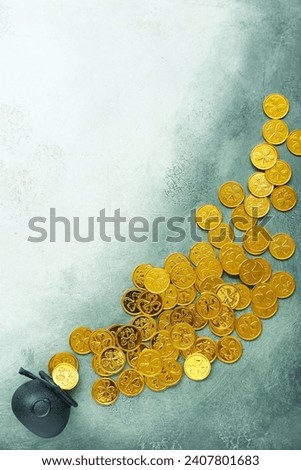 Overturned pot with golden coins on green grunge background. St. Patrick's Day celebration