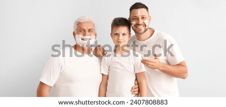 Man, his father and son with shaving foam on their faces on light background