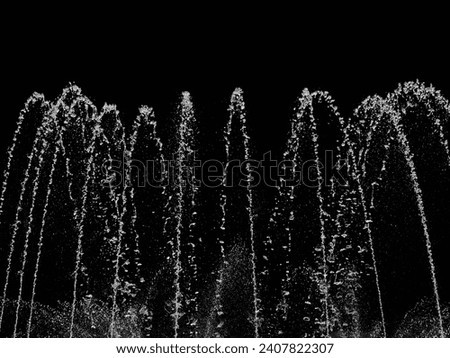 splashing water of fountain with black background Royalty-Free Stock Photo #2407822307