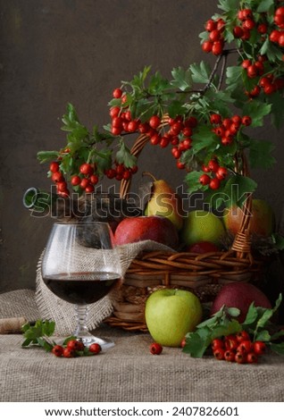 Apples and pears in a basket and a   glass 
 of red wine 