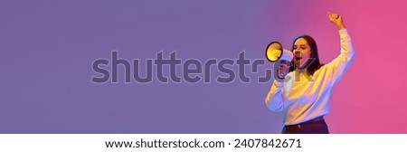 Young attractive brunette woman loudly shouting to megaphone and raising hand against gradient colorful background with negative space for text. Concept of beauty, human emotions, self-expression,