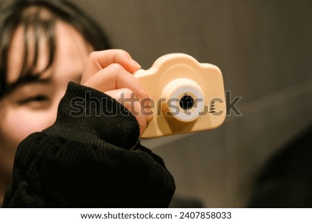 Unrecognizable asian girl taking photo with cute retro camera. Lifestyle aesthetic portrait. Young female tourist having fun.
