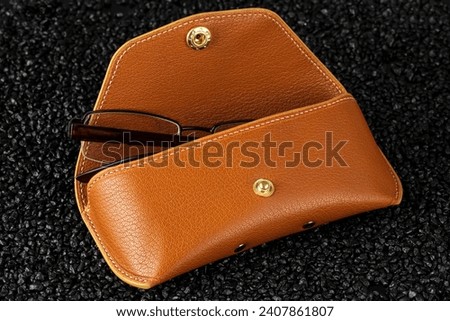 Glasses with leather case on a black background.