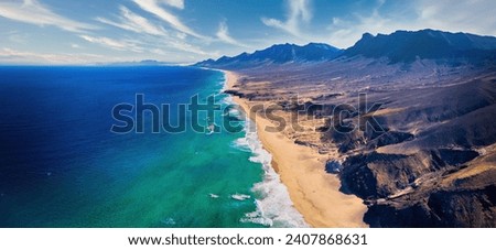 Aerial, panoramic view of the beautiful, unspoiled  Cofete beach on the volcanic island of Fuerteventura, Canary Islands, Spain.  Royalty-Free Stock Photo #2407868631