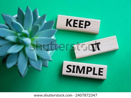 Keep it Simple symbol. Concept words Keep it Simple on wooden blocks. Beautiful green background with succulent plant. Business and Keep it Simple concept. Copy space.