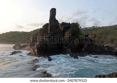 Beautiful rocky beach of East Java, Indonesia in the late afternoon. Low light landscape photography.
