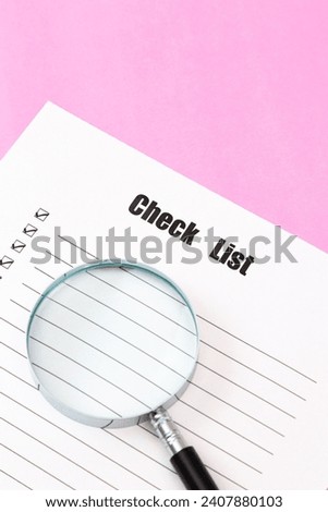 Paper checklist on pink background.