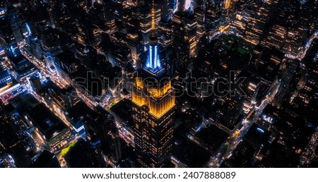 New York City Business Center From Above. Aerial Photo of a Famous Art Deco Skyscraper at Night. Helicopter View on an Impressive Tourist Landmark. Manhattan Panorama with Empire State Building