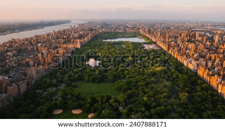 New York Cityscape at Sunset. Aerial Shot from a Helicopter. Modern Skyscraper Buildings Around Central Park in Manhattan Island. Focus on Nature, Trees and Lakes in the Park in the City
