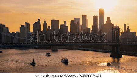 New York City Skyline Aerial Shot from a Helicopter at Sunset. Famous Skyscraper Buildings with Manhattan and Brooklyn Bridges. Busy Diverse Megapolis with Cars, Boats and People Moving Around