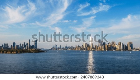 Aerial Photo with Manhattan Island with Office and Apartment Buildings. Hudson River Scenery with Yachts, Boats, and Sun Reflecting From the One World Trade Center Skyscraper