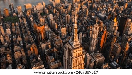 Sunset Aerial View of Empire State Building Spire and a Top Deck Tourist Observatory. New York City Business Center From Above. Helicopter Photo of an Architectural Wonder in Midtown Manhattan