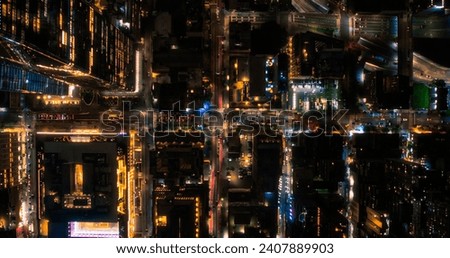 Cinematic Helicopter Night Shot Moving Diagonally Over New York City Avenue Grid System. Top Down Aerial Photo of Congested Streets, Roads, Cars, Nightlife and Tall Modern Skyscrapers