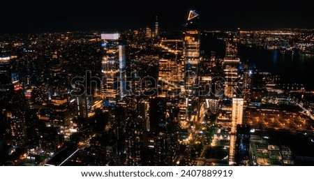 Establishing Helicopter Photo of a New York City Architecture at Night. Long Lens Aerial View of Manhattan Entertainment and Business Districts, Urban Skyline with Skyscrapers in the Distance
