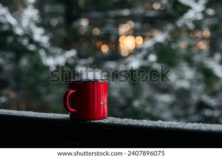 a red coffee mug in a snowy winter forest