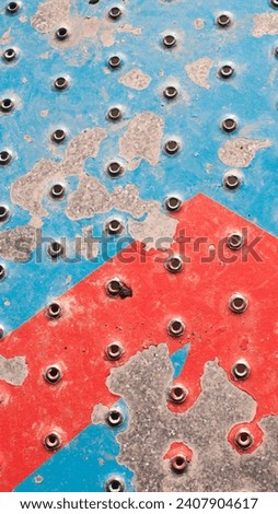 Chipping red and blue paint in metallic ground