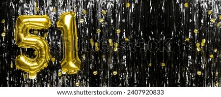 Gold foil balloon number number 51 on a background of black tinsel decoration. Birthday greeting card, inscription fifty-one. Anniversary event. Banner. copy space. Royalty-Free Stock Photo #2407920833