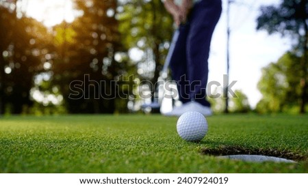 Golfers are putting golf in the evening golf course golf backglound. Golfer hitting golf ball. Sport holiday lifestyle Concept.                                