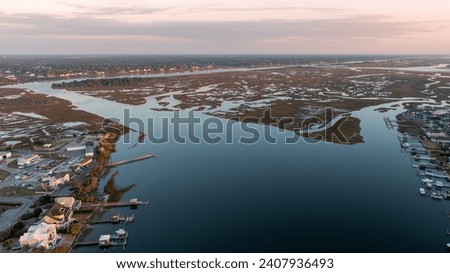 Aerial shot of Wrightsville Beach, North Carolina, showcasing the contrast between the dense marshland and the developed coastline at dusk.