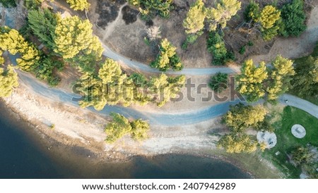 a stunning aerial shot of the lush green and autumn colored trees and a hiking trail at Puddingstone Lake in San Dimas California USA	 Royalty-Free Stock Photo #2407942989