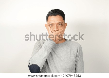 Funny facial expression bad breath with hand covering mouth of Asian man Royalty-Free Stock Photo #2407948253