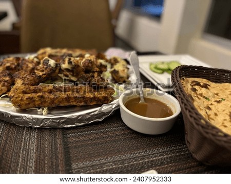 Beautiful picture of barbecue, kebab, chicken tikka green sauce, cucumber and bread roti in Pakistan restaurant